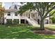Charming two-story home with landscaped yard, large tree, and elevated front porch at 2407 Atlantic Ave, Sullivans Island, SC 29482
