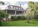 Beautiful home with a lush green lawn, screened porch, and well-maintained landscaping at 2407 Atlantic Ave, Sullivans Island, SC 29482