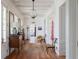 Elegant hallway with wood floors, white walls, decorative lighting and vintage furnishings at 2407 Atlantic Ave, Sullivans Island, SC 29482
