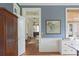 Hallway view with hardwood floors, blue wallpaper, and elegant wooden furniture pieces at 2407 Atlantic Ave, Sullivans Island, SC 29482