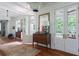 Bright hallway featuring wood floors, white trim, and French doors leading to a porch at 2407 Atlantic Ave, Sullivans Island, SC 29482