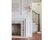 Bright living room features a brick fireplace, wood floors, and a staircase with a wood banister at 2407 Atlantic Ave, Sullivans Island, SC 29482