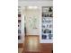 Bright room with wood floors, built in bookshelves, and a doorway that leads to a porch at 2407 Atlantic Ave, Sullivans Island, SC 29482