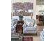 Cozy living room with two upholstered armchairs, wood floors, and a view of a kitchen at 2407 Atlantic Ave, Sullivans Island, SC 29482