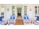 A view of the patio featuring wicker chairs with blue and white striped cushions, and hardwood flooring at 2407 Atlantic Ave, Sullivans Island, SC 29482