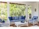 Cozy patio area with wicker furniture, blue cushions, and view of lush greenery at 2407 Atlantic Ave, Sullivans Island, SC 29482