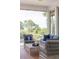 Relaxing outdoor patio with wicker furniture, comfortable blue cushions, and views of the surrounding nature at 2407 Atlantic Ave, Sullivans Island, SC 29482