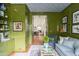 Sitting room with green walls, blue furniture and a view to a bright and airy space at 2407 Atlantic Ave, Sullivans Island, SC 29482