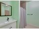 Bathroom with green walls, large mirror, sink and shower with white curtain at 2732 Canebreak Ln, Mount Pleasant, SC 29466