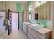 Modern bathroom featuring double sinks, light wood cabinets, aqua tiled stripe accents and a doorway to bedroom at 2732 Canebreak Ln, Mount Pleasant, SC 29466