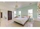 Bedroom with patterned accent wall, windows, modern light fixture, bed, chair, and a mirror at 2732 Canebreak Ln, Mount Pleasant, SC 29466
