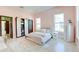 Bright bedroom with a bed between two windows, wooden floor, pink walls, a closet, and a rug at 2732 Canebreak Ln, Mount Pleasant, SC 29466