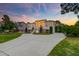 Sunset view of a grand home featuring a wide driveway and manicured front lawn at 2732 Canebreak Ln, Mount Pleasant, SC 29466