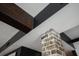 Unique ceiling design with exposed brick column and dark wood beams for an updated modern look at 29 1/2 State St # B, Charleston, SC 29401