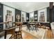 Bright living room featuring dark accent walls, three large windows, hardwood floors, and a modern design at 29 1/2 State St # B, Charleston, SC 29401