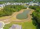 Aerial view of a community pond with walking trails surrounded by lush trees and neighborhood homes at 303 Feldspar Ln, Ladson, SC 29456