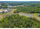 Aerial view showcases the community's ponds and lush trees surrounding neighborhood homes at 303 Feldspar Ln, Ladson, SC 29456