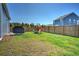 Extensive backyard with lush grass, a wooden fence, and a barbecue grill on the patio at 303 Feldspar Ln, Ladson, SC 29456