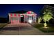 Night view of a charming one-story home with red and green lighting and landscaped front yard at 303 Feldspar Ln, Ladson, SC 29456