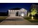Night view of a charming one-story home with a well-lit driveway and landscaped front yard at 303 Feldspar Ln, Ladson, SC 29456