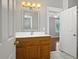 Bathroom featuring a wood vanity with white counter, framed mirror, and a view to the primary bedroom at 304 Pimpernel St, Summerville, SC 29483