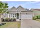 Charming one-story home featuring a pristine two-car garage, landscaped yard, and inviting front porch at 315 Fish Creek Ct, Summerville, SC 29486