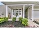 Inviting front porch with white columns, seating, and lush landscaping at 315 Fish Creek Ct, Summerville, SC 29486