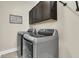 Laundry room featuring stainless steel front-loading washer and dryer under dark wood cabinets at 315 Fish Creek Ct, Summerville, SC 29486