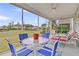 Relaxing screened porch with blue chairs, a glass table, ceiling fan and views of well maintained yard at 315 Fish Creek Ct, Summerville, SC 29486
