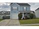 Light-blue, two-story home with blue shutters, an attached garage, and manicured landscaping at 328 Bradley Bend Dr, Moncks Corner, SC 29461