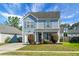 Charming two-story home features light-blue siding, manicured lawn, and attached garage at 328 Bradley Bend Dr, Moncks Corner, SC 29461