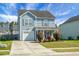 Charming two-story home features light-blue siding, manicured lawn, and attached garage at 328 Bradley Bend Dr, Moncks Corner, SC 29461