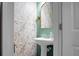 Stylish powder room featuring elegant pedestal sink, gold mirror and distinctive floral wallpaper at 328 Bradley Bend Dr, Moncks Corner, SC 29461