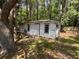 Exterior shot of the shed with white siding, a door, and windows, surrounded by trees in the backyard at 3342 Habitat Blvd Blvd, Johns Island, SC 29455