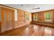 Spacious bedroom features wood walls, wood floors, and multiple windows that provide natural light at 3936 Lodge Hwy, Smoaks, SC 29481