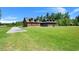 Sprawling log home on a lush green lawn with a long driveway and mature trees at 3936 Lodge Hwy, Smoaks, SC 29481