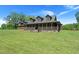 Charming log home with a covered porch, stone foundation, and large front yard at 3936 Lodge Hwy, Smoaks, SC 29481