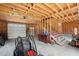 Spacious unfinished garage with exposed beams and stairs leading to a second story at 3936 Lodge Hwy, Smoaks, SC 29481