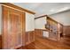 Hallway featuring wood paneling, hardwood floors, and a wooden staircase with white railings at 3936 Lodge Hwy, Smoaks, SC 29481