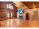 Spacious living room features a stone fireplace, wood walls, wood floors, and many windows at 3936 Lodge Hwy, Smoaks, SC 29481