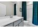 Stylish bathroom featuring a vanity with a white sink, gray cabinets, and a tub-shower combo with teal curtains at 427 W Respite Ln, Summerville, SC 29483