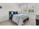 Bright bedroom with white shuttered windows, bed with blue accents, and neutral carpet at 427 W Respite Ln, Summerville, SC 29483