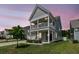 Charming two-story home with a welcoming front porch and well-maintained lawn at dusk at 427 W Respite Ln, Summerville, SC 29483
