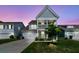 Charming two-story home with a covered porch and beautifully landscaped front yard at twilight at 427 W Respite Ln, Summerville, SC 29483