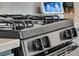 Close-up of a modern gas range with stainless steel knobs and black grates at 427 W Respite Ln, Summerville, SC 29483