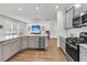 Open-concept kitchen with stainless steel appliances, white countertops, and hardwood floors at 427 W Respite Ln, Summerville, SC 29483