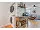 Open-concept living room features stackable washer/dryer and a coffee bar, providing space-saving convenience and stylish functionality at 4709 Marlboro Pl, North Charleston, SC 29405