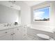 Bright bathroom with double vanity, a soaking tub, and a window with a view of the blue sky at 4979 Lake Palmetto, North Charleston, SC 29418