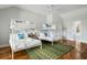 Bright bedroom with two sets of white bunkbeds, hardwood floors, a ceiling fan, and a decorative green rug at 4979 Lake Palmetto, North Charleston, SC 29418