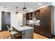 Modern kitchen with stainless steel appliances, marble countertops, island with bar stools, and dark brown cabinetry at 5 Gadsdenboro St # 416, Charleston, SC 29401